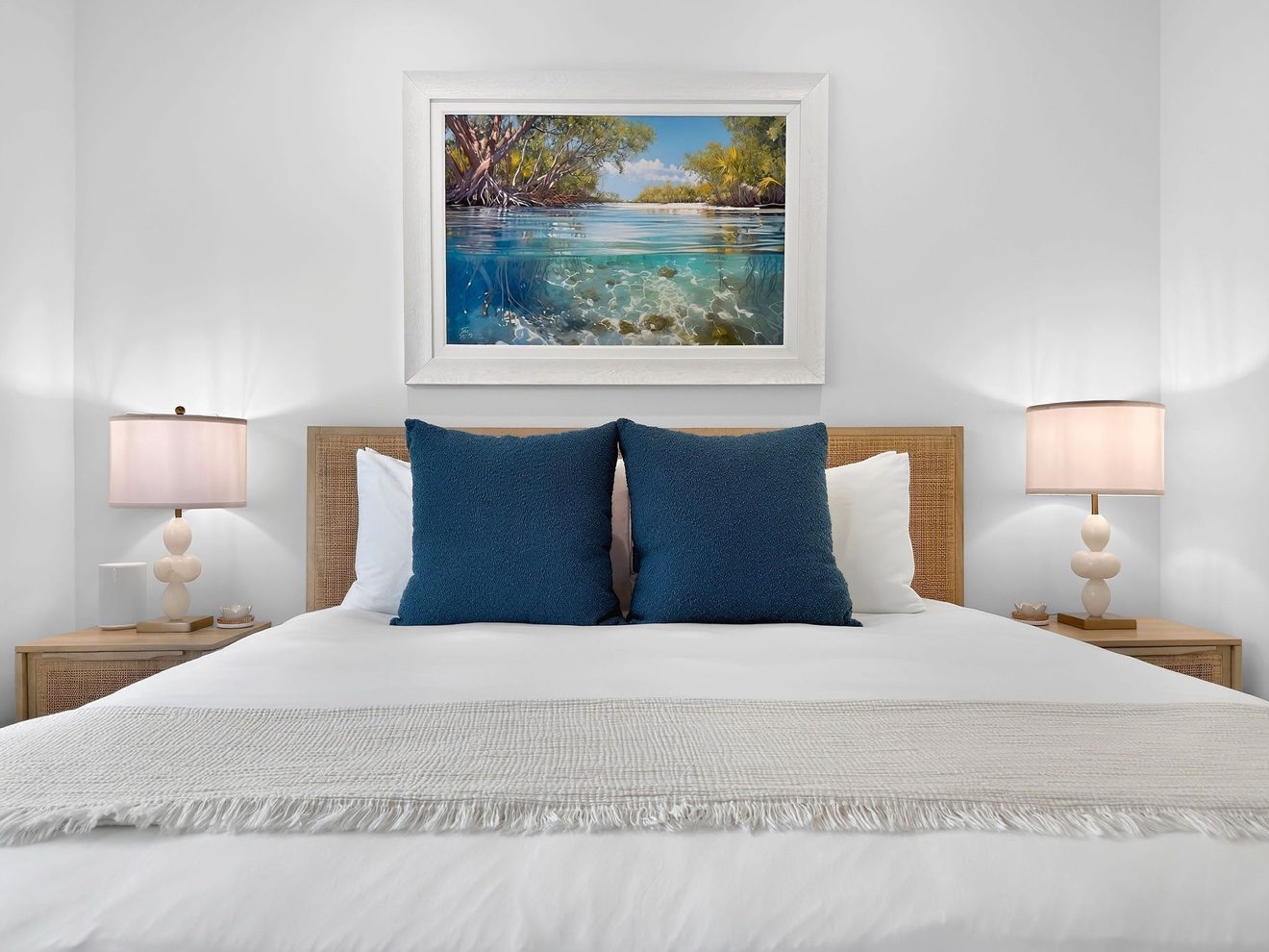 Guest bedroom with king bed and coastal artwork