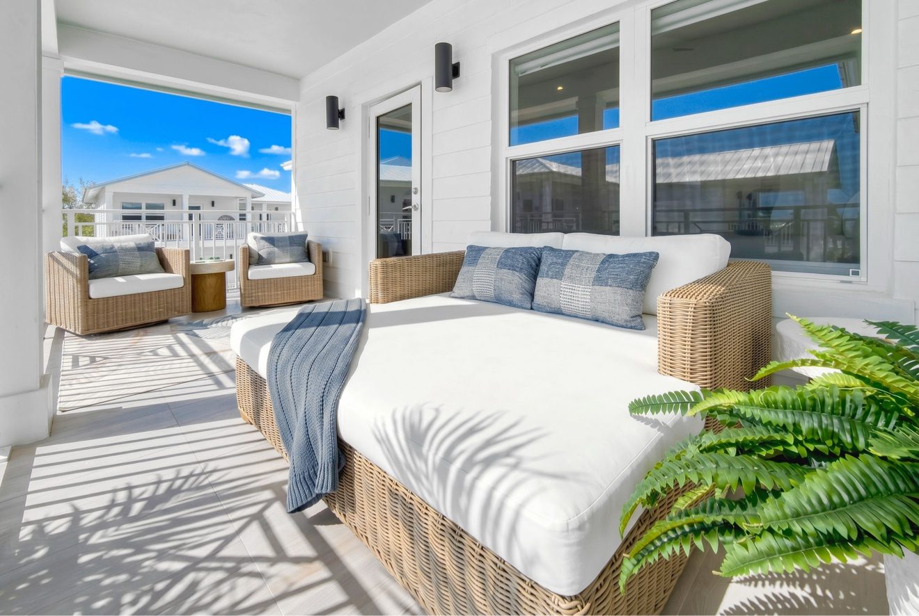 Primary suite with king bed, desk, and private balcony with ocean views