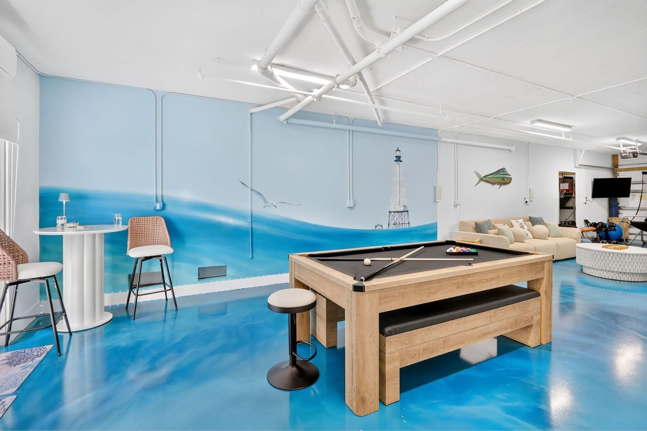 Game room with pool table, lounge seating, and ocean mural